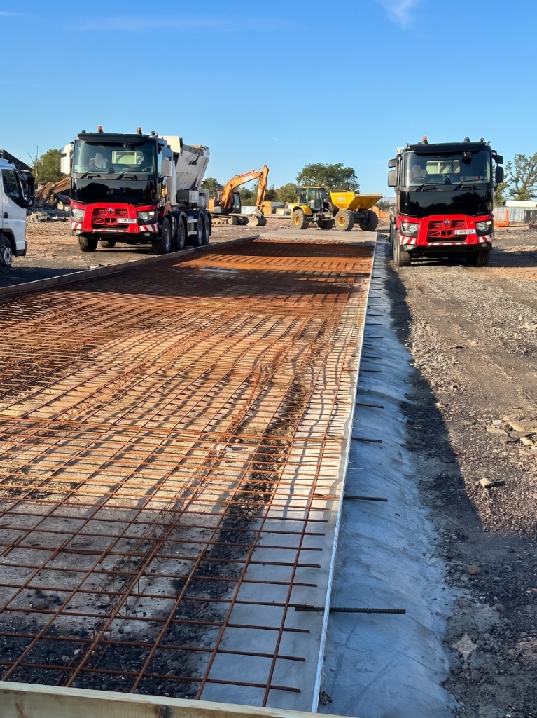 Large Construction Site Pour with Rebar and Trucks